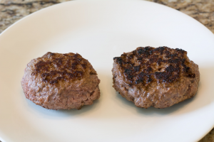 Two plain burger patties on a plate